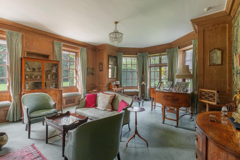 Back again with the wood panelling, the drawing room has sash windows, each with their own cushioned seat, so you can curl up with a book while it's raining outside. The French doors lead out onto the rose garden.
