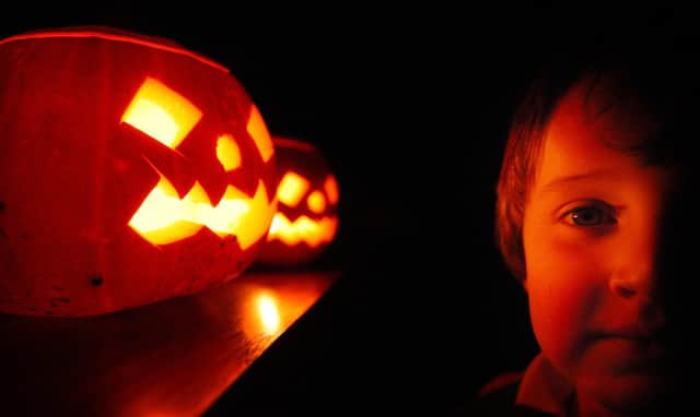 A child enjoys traditional candle-lit Halloween pumpkins  (Photo by Peter Macdiarmid/Getty Images)