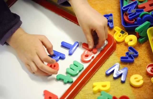 Children playing with letters. Picture: Dominic Lipinski/PA