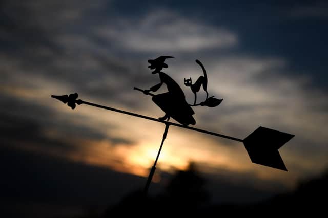 The silhouette of a weather vane depicting a witch and her black cat on a broom. Photo by FABRICE COFFRINI/AFP via Getty Images