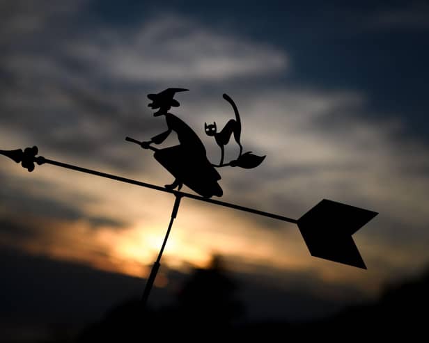 The silhouette of a weather vane depicting a witch and her black cat on a broom. Photo by FABRICE COFFRINI/AFP via Getty Images