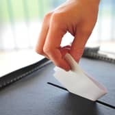 File photo of a person putting a vote into a ballot box
