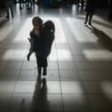 : A refugee girl carries a sibling (Photo by Christopher Furlong/Getty Images)
