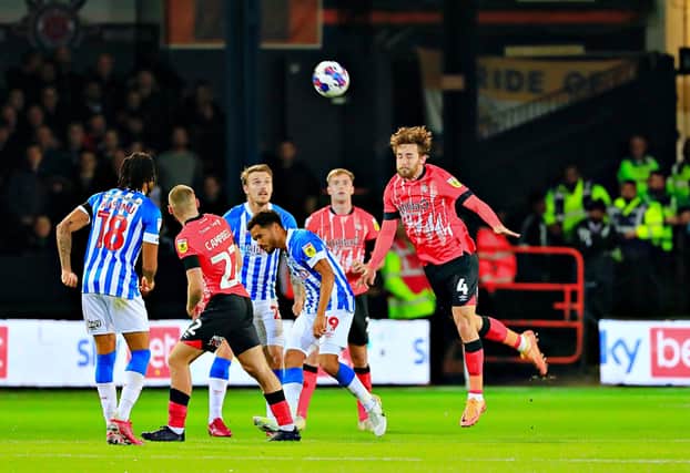 Town defender Tom Lockyer heads clear against Huddersfield on Tuesday night