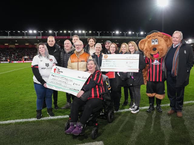 Tom Lockyer poses with Luton and Cherry trust fundraisers with cheques for the British Heart Foundation during the Premier League match. Photo by David Horn.
