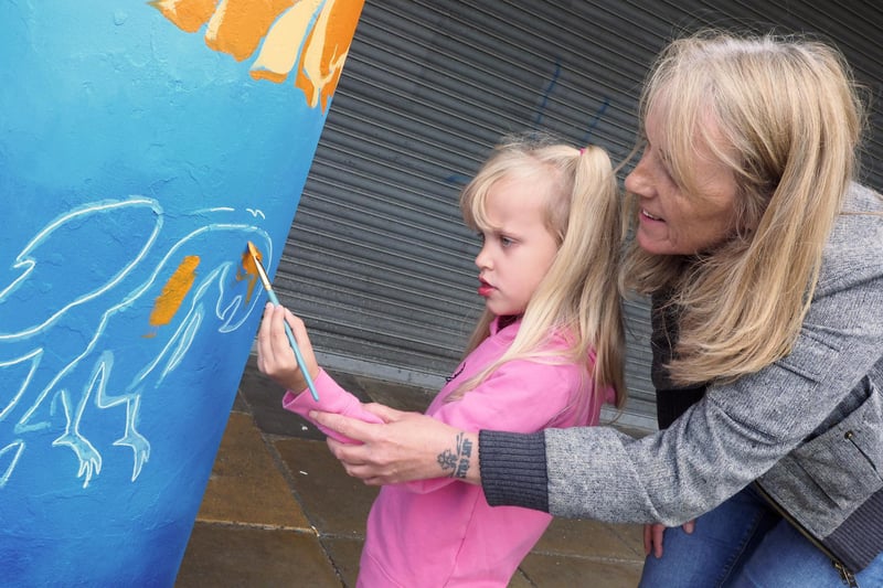 A girl was helped by her grandma as she spruced up the shops