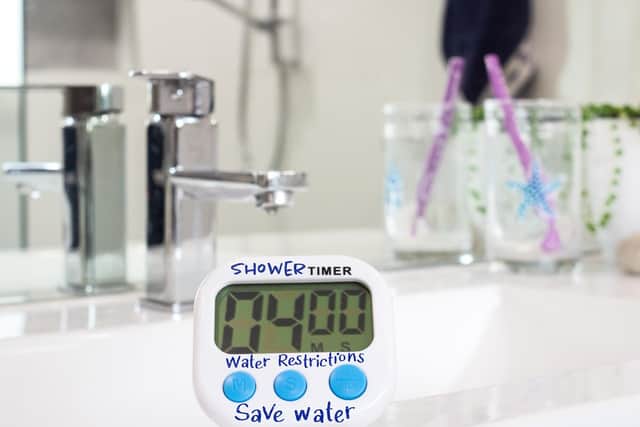 Homemade shower timer in bathroom, used to time showers due to water restrictions caused by drought conditions through climate change (photo: Adobe)
