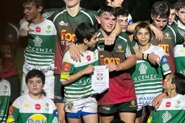 Luton Under 16 rugby team captain Ben Spary (centre right, holding flag) whose passion for the game saw his side brought back from almost certain closure to two stunning victories over Portugal