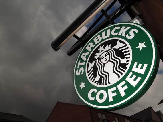The Starbucks logo hangs outside one of the company's cafes. Photo by Christopher Furlong/Getty Images