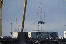 A car being removed from the fire-damaged Luton Airport car park via crane. Picture: Natalie Cummings