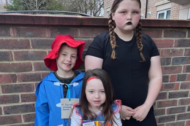 Pictured are Finley, aged eight, dressed as Paddington Bear; Tallulah, 11, as Wednesday Addams; and Scarlett, five, dressed as Roald Dahl heroine Matilda