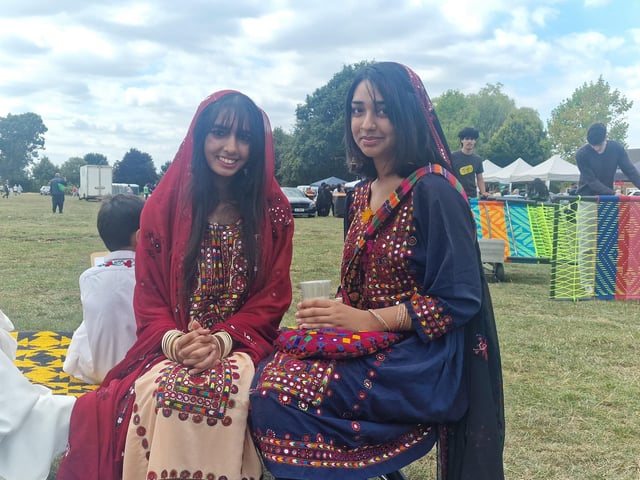 Two of the attendees in traditional dress enjoying the event.