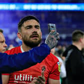 A Huddersfield supporter attempts to video Luton midfielder Robert Snodgrass after Monday's defeat