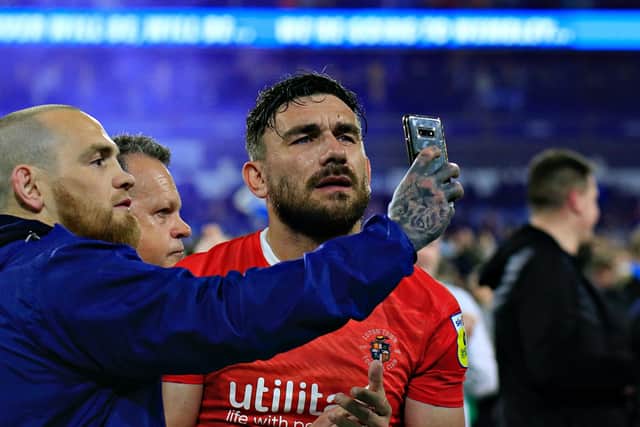 A Huddersfield supporter attempts to video Luton midfielder Robert Snodgrass after Monday's defeat