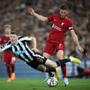 Elliot Anderson takes a tumble after being challenged by Liverpool midfielder James Milner