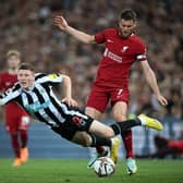 Elliot Anderson takes a tumble after being challenged by Liverpool midfielder James Milner