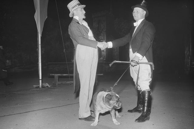 A bulldog with two men the end of the pageant. What is more English than an English bulldog?