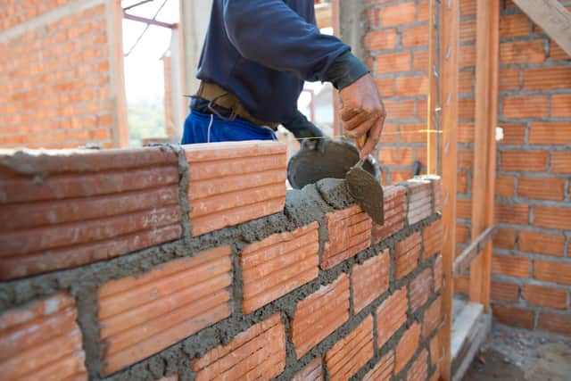 ADOBE STOCK
Worker building masonry house wall with bricks 