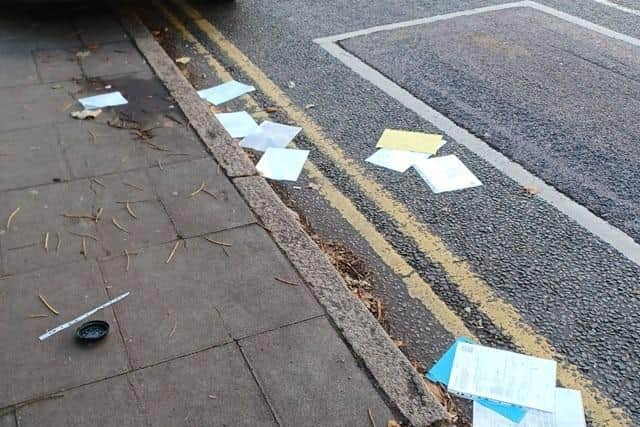 Rashid's papers strewn across a street in Luton