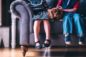 Children sit on a sofa with a dog. (Picture:  Pexels via Pixabay)