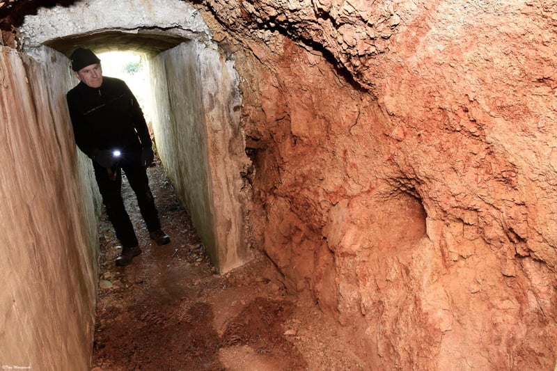 Colonel Richard Kemp, looking at a hand dug, rock tunnel, in SS Lager Sylt.