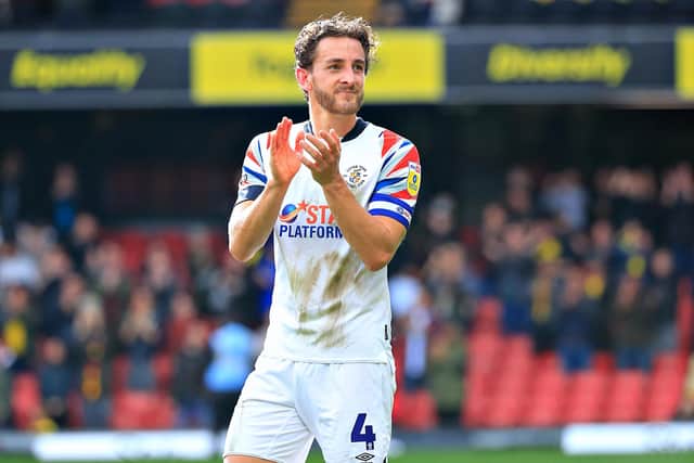 Tom Lockyer applauds the travelling Luton supporters after Town's defeat at Watford earlier in the season