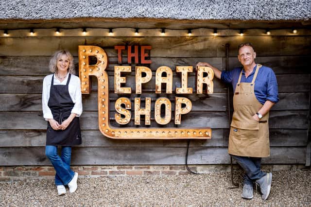 Suzie and Steve Fletcher by The Repair Shop sign. Picture: Guy Levy/Ricochet Ltd