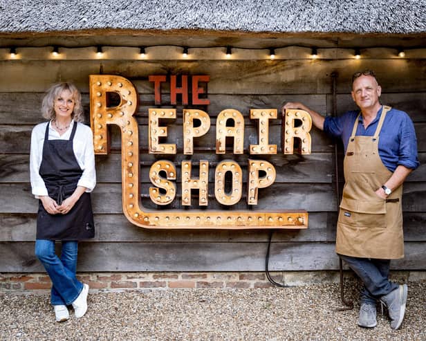 Suzie and Steve Fletcher by The Repair Shop sign. Picture: Guy Levy/Ricochet Ltd