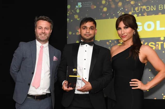 Director of Greystone Solicitors Bilal Farooq (centre) is handed the gold award