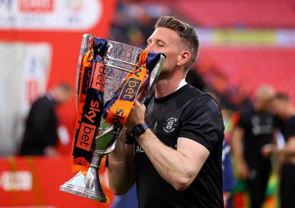 Rob Edwards, Manager of Luton Town, celebrates with the trophy after the team's victory and promotion to the Premier League
