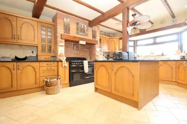 The kitchen has exposed beams, an island, granite worktops, range cooker, and space for additional appliances