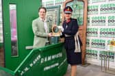 Founder of Green Doors Joseph Holman receives a King's Award for Enterprise from a skip, in a nod to the business' origins