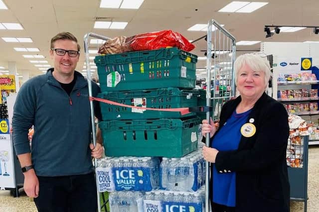 Ben Bodsworth, BT Events and Carnival Production Manager collecting water bottles from Tesco Community Champion Karen Linley 