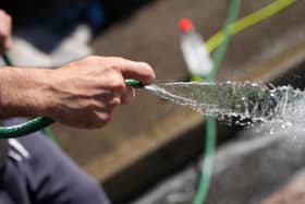 A man uses a hosepipe. Photo by Christopher Furlong/Getty Images)
