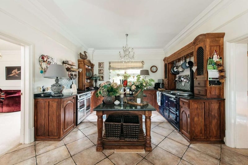 The property has a traditional kitchen and breakfast room with a four-oven Aga. There is a central island unit with a granite preparation area that divides into a breakfast area. Off of this room is a fitted utility room which has a walk-in wine store, leading to the garage wing.