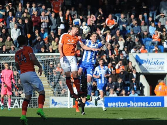 Jake Gray challenges for a header before being replaced in the first half at Colchester