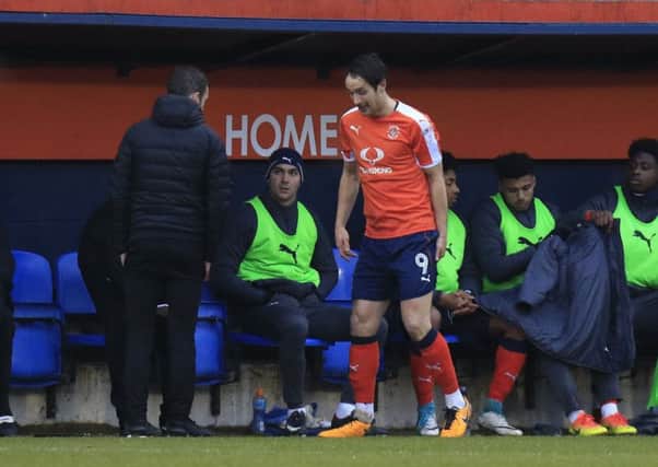 Danny Hylton holds his hamstring after coming off against Morecambe