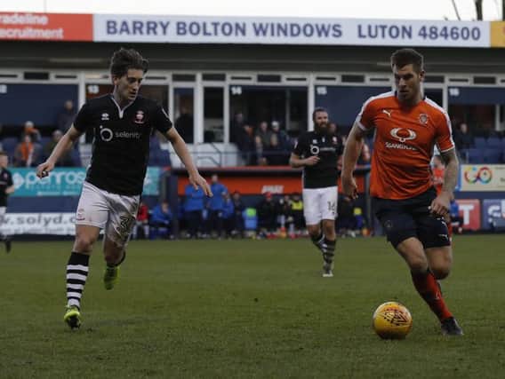 Lincoln's Alex Woodyard tracks James Collins during the recent clash at Kenilworth Road