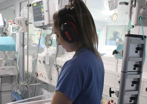 NICU nurse demonstrating headphones