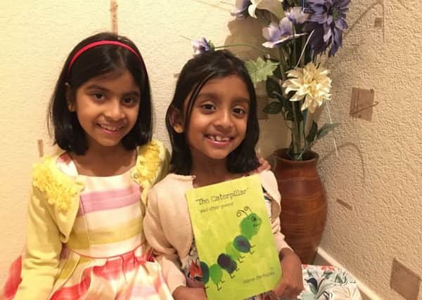 Auvea (right) with her twin sister, Archanaa, who is busy writing a story!
