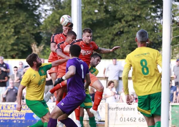 James Collins goes up for an aerial challenge against Hitchin