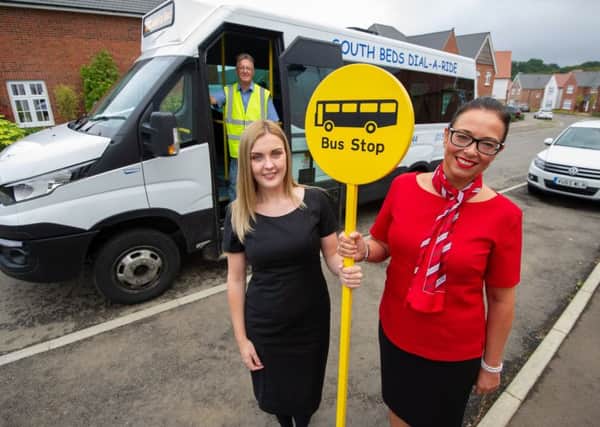 Redrow sales assistants Emma Clark and Rachel West stand with bus driver Peter Waller at the Redrow Caddington Wood development near Luton. Credit: Matthew Power.