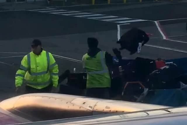 Video grab of the moment airport staff were caught carelessly throwing luggage from the plane's hold onto a nearby cart