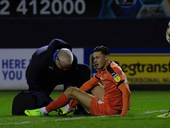 Town attacker Harry Cornick receives treatment after rolling his ankle