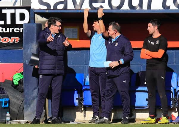 Mick Harford talks to his staff during Saturday's 1-1 draw with Coventry