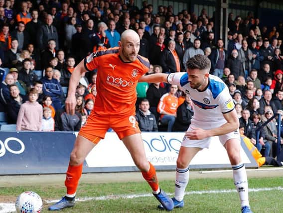 Hatters attacker Danny Hylton shields the ball from a Rochdale defender