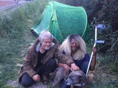 The couple and their dog Biggy sitting in front of the green tent that has been stolen.