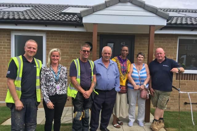 Cllr Tom Shaw (centre), with Cllr Jacqui Burnett and first Roman Way resident Shirley Long to his left, joined by council officers and staff who helped with development of the homes