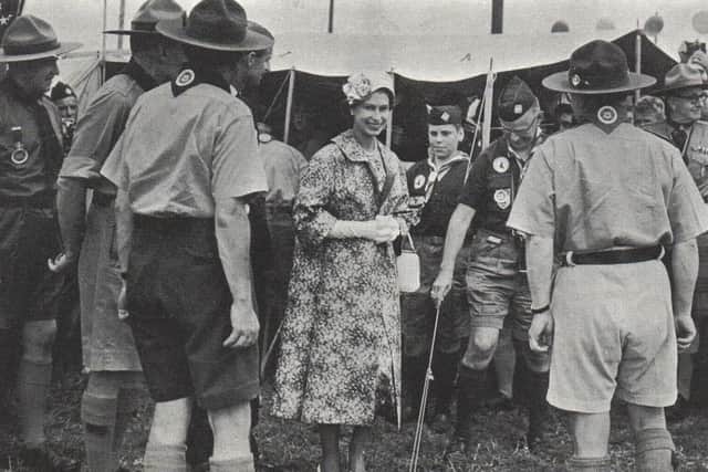 The Queen tiptoes in the grass at 1957 Jamboree