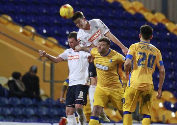 Alex Lacey heads clear against Mansfield last season